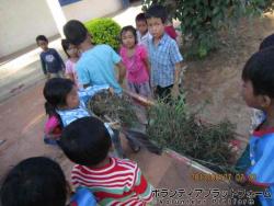 みんなで校庭を大掃除！雑草を集めて担架で運んでます。 ぼらぷらカンボジア 教育ボランティア